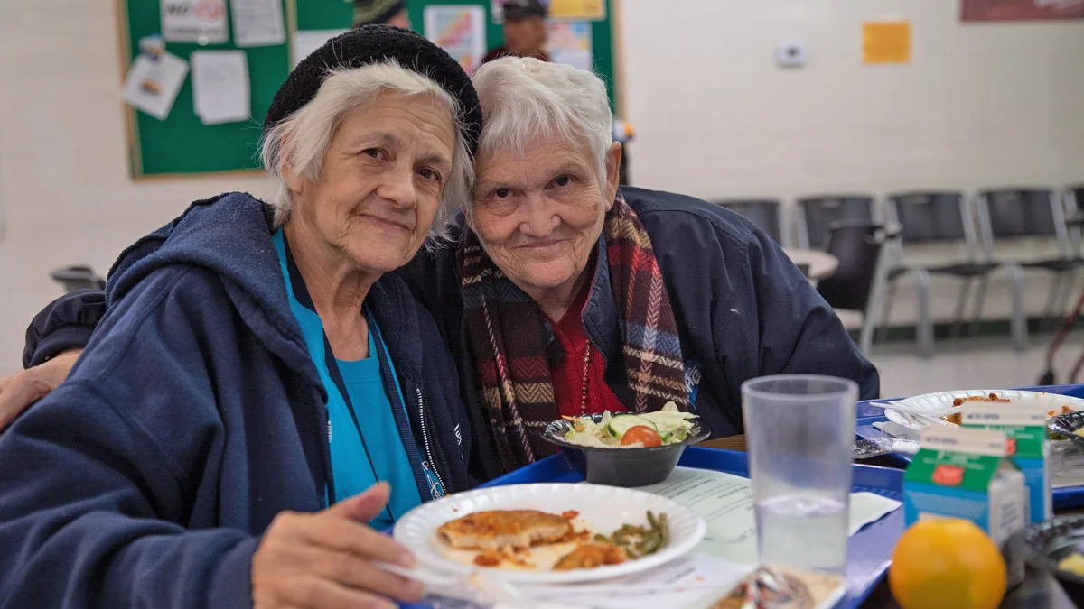 Photo of two older women enjoying a meal provided by Three Square